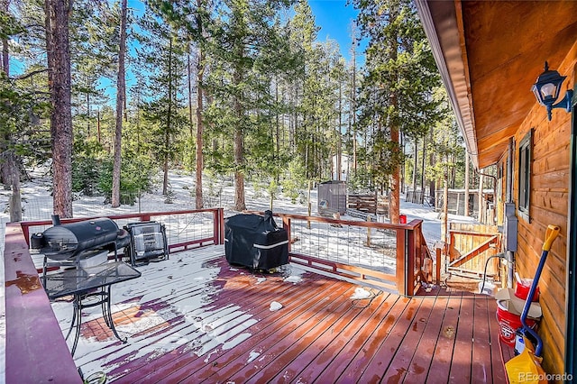 snow covered deck featuring a grill