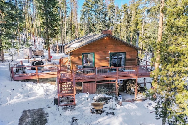 snow covered property with a wooden deck