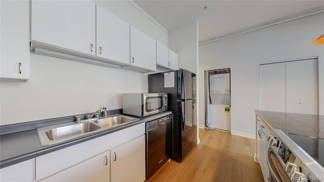 1521 Central St Unit 2D, Denver, CO 80211 - kitchen featuring stacked washer / drying machine, stainless steel appliances, white cabinetry, light wood finished floors, and dark countertops
