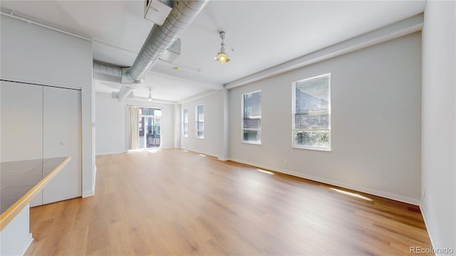 1521 Central St Unit 2D, Denver, CO 80211 - unfurnished living room with light wood-style floors and baseboards