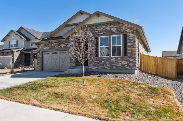 view of front of house with driveway, stone siding, fence, and a front lawn