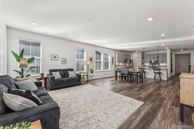 living room with baseboards, dark wood-type flooring, and recessed lighting