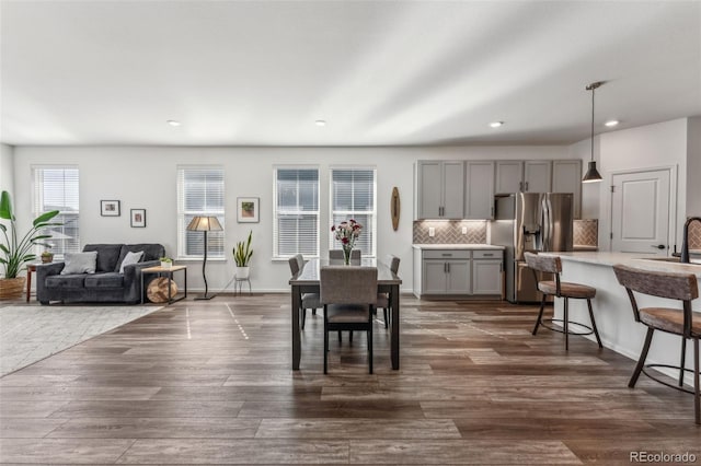 dining area with baseboards, dark wood-type flooring, and recessed lighting