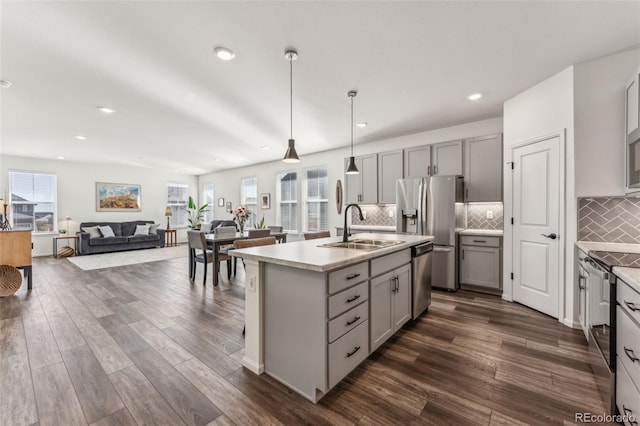 kitchen featuring stainless steel appliances, dark wood-type flooring, gray cabinets, and a sink