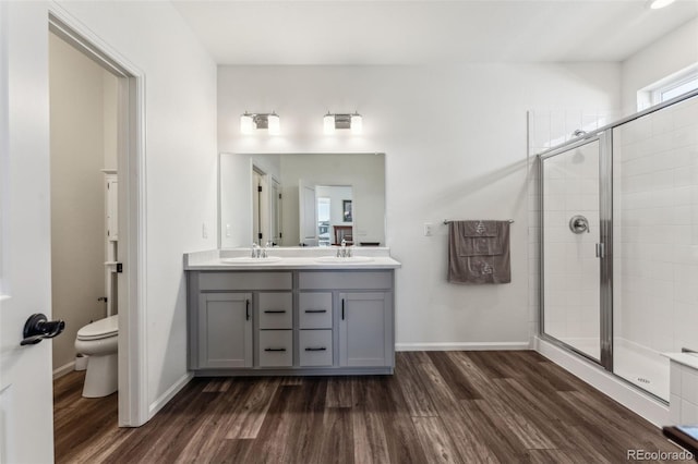 full bathroom featuring wood finished floors, a stall shower, and a sink