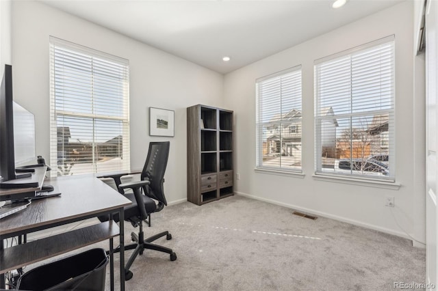 home office featuring a wealth of natural light, carpet, visible vents, and baseboards