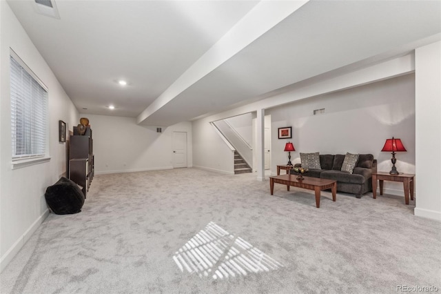 living room featuring light carpet, baseboards, visible vents, and stairway