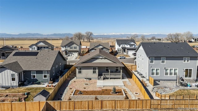 rear view of house with entry steps, a fenced backyard, a residential view, a patio area, and a mountain view