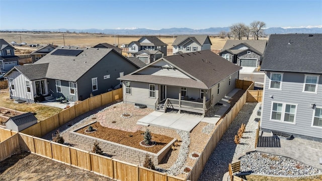 rear view of property featuring a vegetable garden, a patio, a mountain view, a residential view, and a fenced backyard