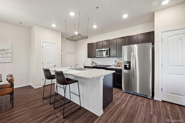 4644 High Springs Ct, Colorado Springs, CO 80917 - kitchen with stainless steel appliances, an island with sink, dark wood-style flooring, a breakfast bar area, and light countertops