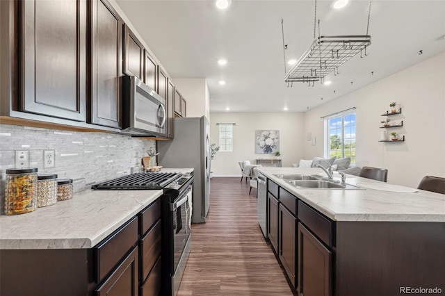 4644 High Springs Ct, Colorado Springs, CO 80917 - kitchen featuring stainless steel appliances, open floor plan, dark wood-style flooring, an island with sink, and plenty of natural light