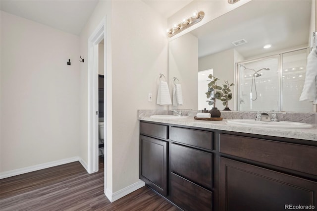 4644 High Springs Ct, Colorado Springs, CO 80917 - bathroom featuring wood finished floors, double vanity, and a shower stall