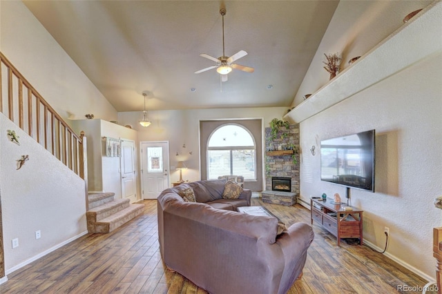 living room featuring ceiling fan, high vaulted ceiling, dark hardwood / wood-style flooring, and a fireplace