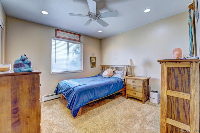 bedroom featuring a baseboard heating unit, light colored carpet, and ceiling fan