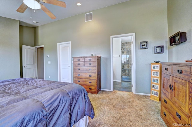 bedroom featuring a high ceiling, ensuite bathroom, light colored carpet, and ceiling fan