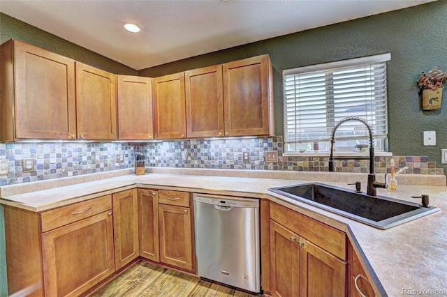 kitchen featuring sink, backsplash, dishwasher, and light wood-type flooring