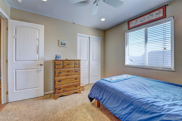 bedroom featuring light carpet, a closet, and ceiling fan