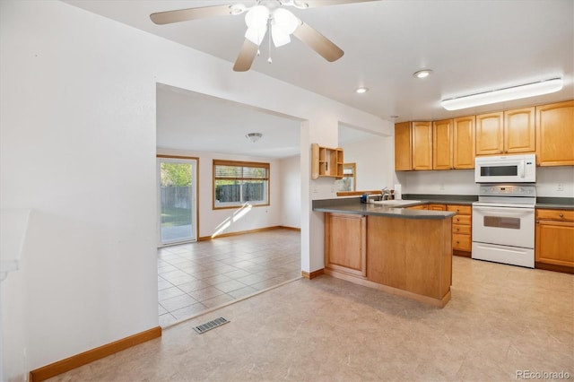 16246 E Hamilton Pl, Aurora, CO 80013 - kitchen with white appliances, dark countertops, a sink, baseboards, and a peninsula