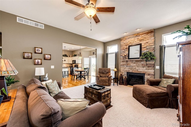 34942 Wagon Wheel Trl, Elizabeth, CO 80107 - living area with a ceiling fan, healthy amount of natural light, a stone fireplace, and light wood-type flooring