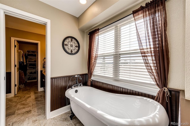 34942 Wagon Wheel Trl, Elizabeth, CO 80107 - bathroom featuring a spacious closet, a freestanding tub, and wainscoting