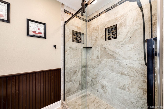 34942 Wagon Wheel Trl, Elizabeth, CO 80107 - full bathroom featuring tiled shower and wainscoting