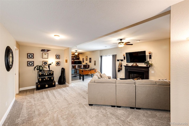 34942 Wagon Wheel Trl, Elizabeth, CO 80107 - living area with light colored carpet, a glass covered fireplace, baseboards, and a ceiling fan