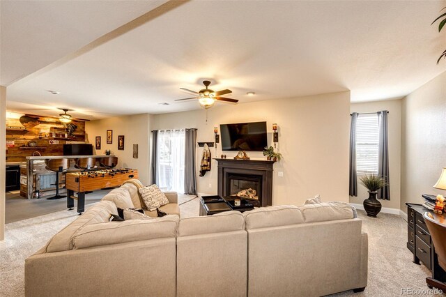 34942 Wagon Wheel Trl, Elizabeth, CO 80107 - living room featuring a ceiling fan, light colored carpet, a glass covered fireplace, and baseboards