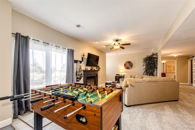 34942 Wagon Wheel Trl, Elizabeth, CO 80107 - game room featuring a ceiling fan, a glass covered fireplace, light colored carpet, and baseboards