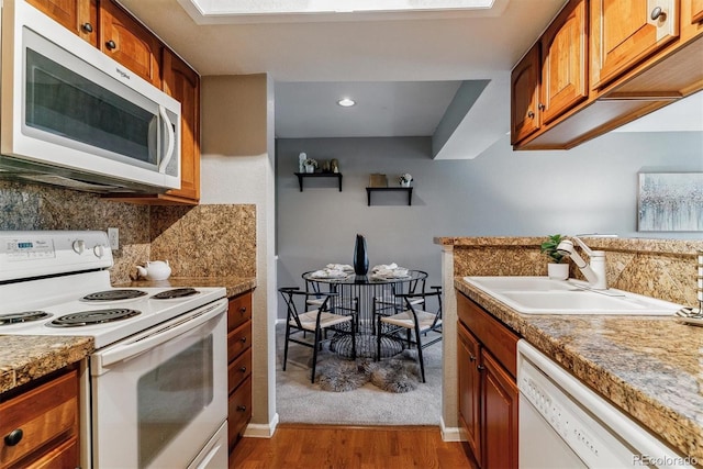 9283 E Arbor Cir Unit C, Englewood, CO 80111 - kitchen with white appliances, light wood-style flooring, tasteful backsplash, and brown cabinetry