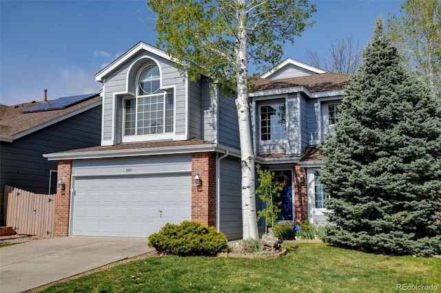 traditional-style home with fence, a front yard, brick siding, concrete driveway, and an attached garage