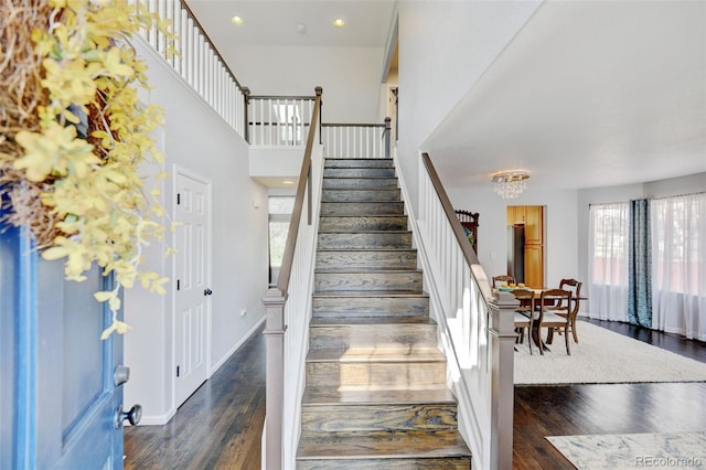 stairs with plenty of natural light, recessed lighting, baseboards, and wood finished floors