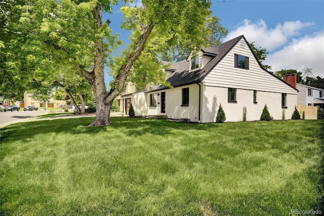 1980 S Kearney Way, Denver, CO 80224 - view of side of property with a lawn, brick siding, and roof with shingles