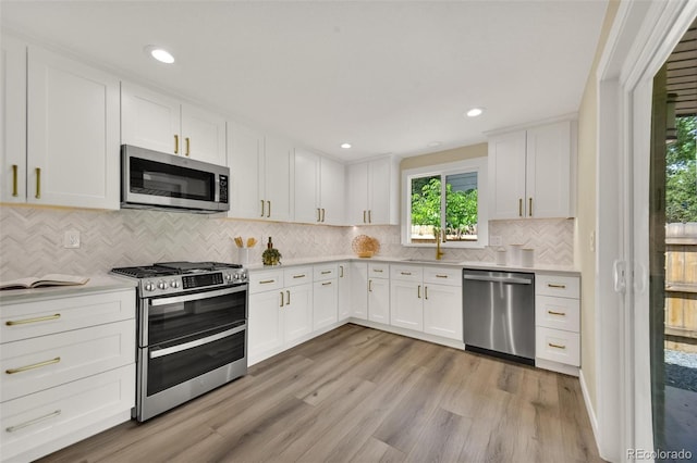 1980 S Kearney Way, Denver, CO 80224 - kitchen featuring stainless steel appliances, light countertops, white cabinets, light wood-style flooring, and recessed lighting