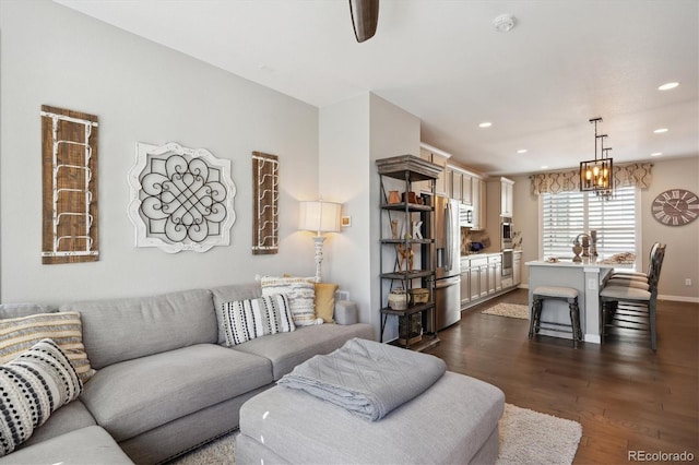 living room with dark wood-type flooring and a notable chandelier