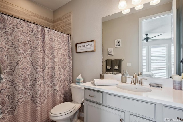 bathroom featuring toilet, vanity, a shower with shower curtain, and ceiling fan