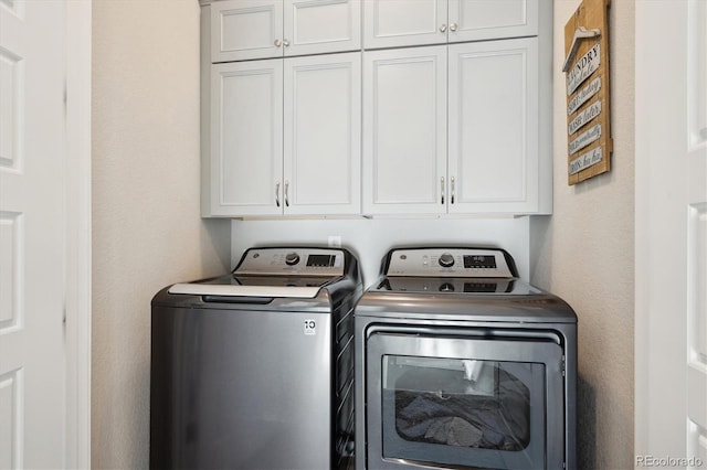 laundry room with independent washer and dryer and cabinets