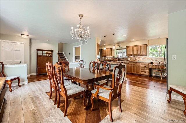 2023 S Rifle St, Aurora, CO 80013 - dining space with a chandelier, light wood-style flooring, stairway, baseboards, and recessed lighting