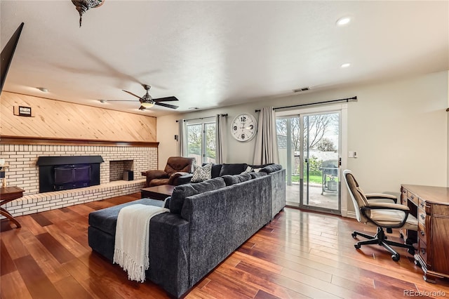 2023 S Rifle St, Aurora, CO 80013 - living area with a ceiling fan, a fireplace, wood-type flooring, wood walls, and recessed lighting