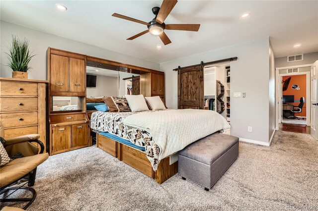 2023 S Rifle St, Aurora, CO 80013 - bedroom featuring light colored carpet, a barn door, a walk in closet, baseboards, and recessed lighting