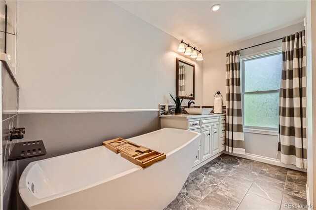 2023 S Rifle St, Aurora, CO 80013 - bathroom with marble finish flooring, vanity, a freestanding bath, plenty of natural light, and recessed lighting