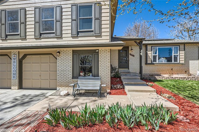 2023 S Rifle St, Aurora, CO 80013 - view of front of property with brick siding, roof mounted solar panels, an attached garage, and driveway