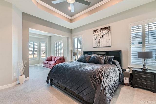 carpeted bedroom featuring ornamental molding, ceiling fan, and a tray ceiling