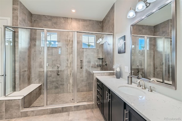 bathroom with tile patterned flooring, walk in shower, and vanity