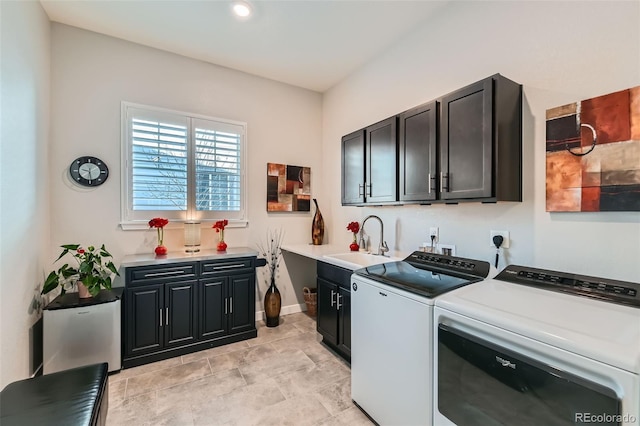 clothes washing area with cabinets, washing machine and clothes dryer, and sink