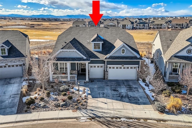 view of front of property with a garage, a porch, and a mountain view