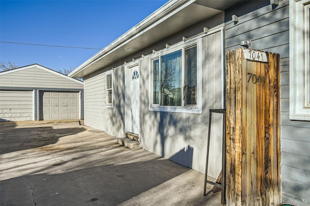 view of property exterior with an outbuilding and a detached garage