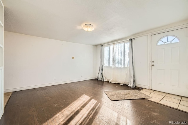 foyer entrance with hardwood / wood-style flooring and baseboards