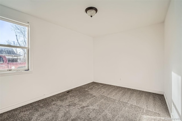 spare room featuring carpet flooring, visible vents, and baseboards