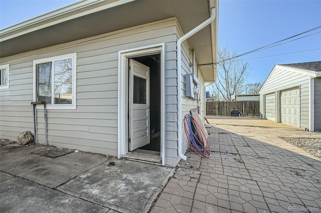 exterior space with a garage, fence, and an outbuilding