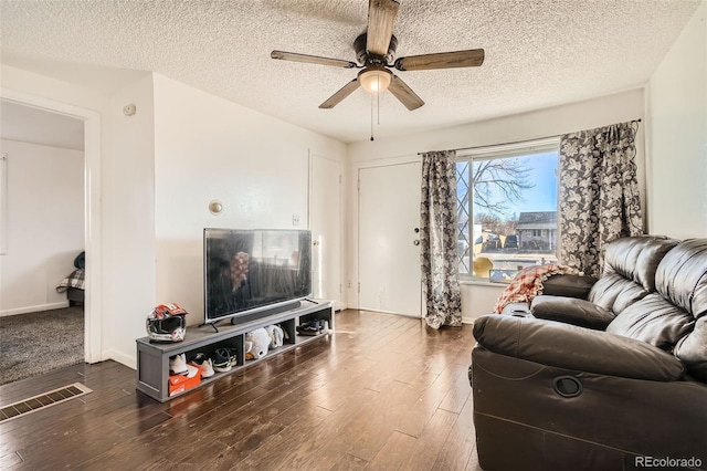 living room featuring baseboards, visible vents, ceiling fan, wood finished floors, and a textured ceiling